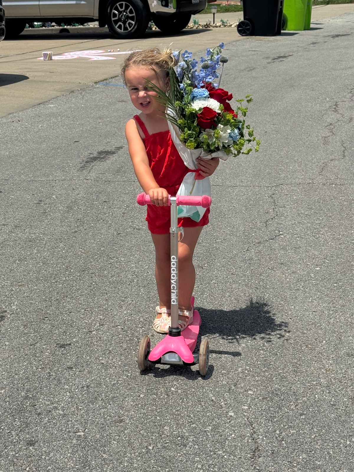Rosi delivering red, white, and blue flowers on a pink scooter