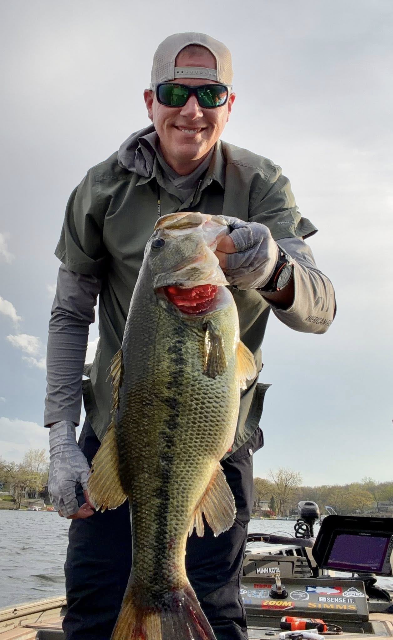 Kyle Carpenter holding a Lake Waukomis bass from a boat